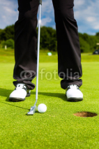 Naklejki Golf player putting ball in hole