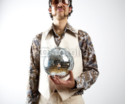 Naklejki Portrait of a retro man in a 1970s leisure suit and sunglasses holding a disco ball - mirror ball