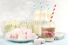 Naklejki Milk in bottles with paper straws on table