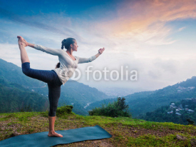 Naklejki Woman doing yoga asana Natarajasana outdoors at waterfall
