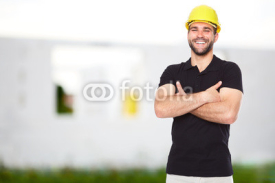 Naklejki Young smiling builder standing before building
