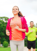 Naklejki smiling couple running outdoors