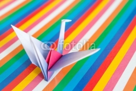 Fototapety An origami bird on a colorful stripes background.