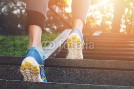 Naklejki Athlete runner feet running in nature, closeup on shoe. Female athlete running on stairs. Woman fitness, running, jogging, sport, fitness, active lifestyle concept