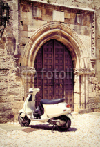 Obrazy i plakaty White vintage scooter near medieval gate