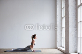 Naklejki Woman exercising yoga indoors.