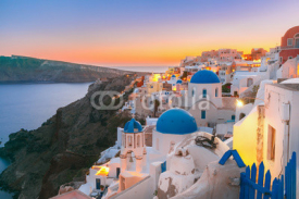 Naklejki Picturesque view, Old Town of Oia or Ia on the island Santorini, white houses and church with blue domes at sunset, Greece