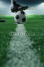 Obrazy i plakaty Close up of foot on top of soccer ball on the line, side view, stadium