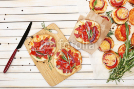 Naklejki Small pizzas on baking paper close up