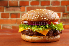 Fototapety Hamburger on table with red brick wall background
