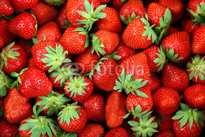 Fresh strawberry fruit as a backdrop.