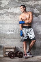 Fototapety attractive boxer man standing on the wall and looking aside