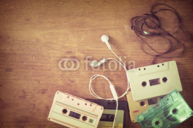 Obrazy i plakaty Top view (above) shot of retro tape cassette with earphone on wood table - vintage color effect styles.