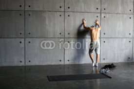 Naklejki Man at the wall in the gym resting after exercise