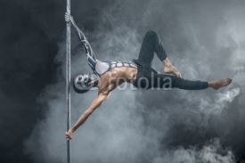 Fototapety Male pole dancer posing in dark studio