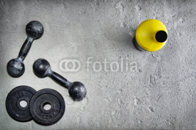 Naklejki Fitness or bodybuilding background. Old iron dumbbells on conrete floor in the gym. Photograph taken from above, top view