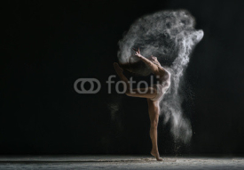 Obrazy i plakaty Concept. Flexible girl dancing in cloud of dust