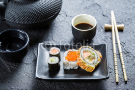 Naklejki Closeup of sushi on the black ceramic dish