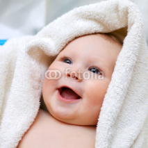 Naklejki A beautiful smiling baby wrapped in quilt