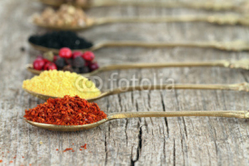 Naklejki Old spoons with spices on wooden background