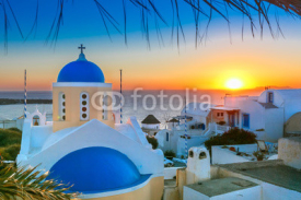 Fototapety Picturesque view, Old Town of Oia or Ia on the island Santorini, white houses and church with blue domes at sunset, Greece