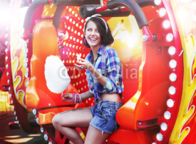 Fototapety Lifestyle. Happy Woman Eating Sweetened Cotton Candy in Funfair