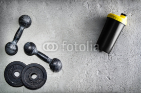 Fototapety Fitness or bodybuilding background. Old iron dumbbells on conrete floor in the gym. Photograph taken from above, top view