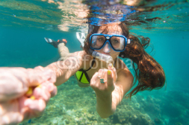 Fototapety Frau in gelben Bikini schnorchelt im Meer und macht lockende Geste
