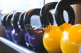 Fototapety kettlebelll / Grupo de kettlebells amarillas y moradas en gimnasio