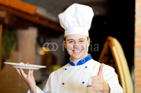 Naklejki Male chef presenting food in a restaurant