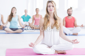 Obrazy i plakaty People sitting concentrated on yoga class