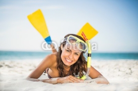 Naklejki Smiling woman wearing flippers at the beach