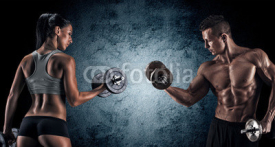 Naklejki Athletic man and woman with a dumbells.
