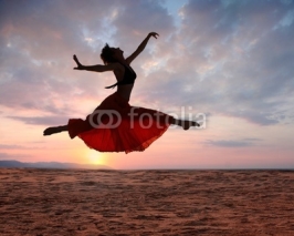 Naklejki Jumping woman at sunset