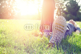 Fototapety Female athlete resting and relaxing after workout. Woman lying down on grass. Healthy lifestyle and happiness concept