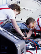 Naklejki Two motor mechanic checking the air handling unit of a car