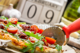Fototapety Cutting baked pizza in the background with calendar