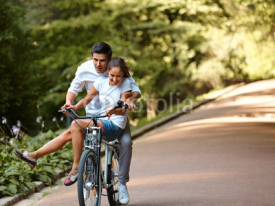 Fototapety Happy couple cycling in the summer park