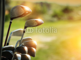 Naklejki Golf clubs drivers over green field background