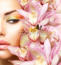 Naklejki Beautiful Girl With Orchid Flowers. Beauty Model Woman Face