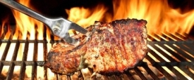 Naklejki Grilled Pork Chop on Flaming BBQ Grill.