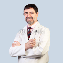 Fototapety Portrait of happy middle-aged dentist on a pale background, wear