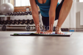 Naklejki frau macht dehnübungen im fitness-center auf einer matte