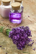 Naklejki Bouquet of fresh purple flowers and bottles of soap and lotion