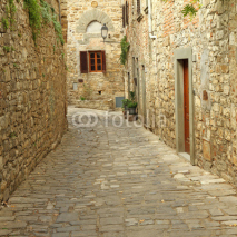 Naklejki narrow  paved street and stone walls in italian village