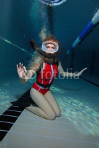 Obrazy i plakaty Female scuba diver with red swimsuit diving in the pool 