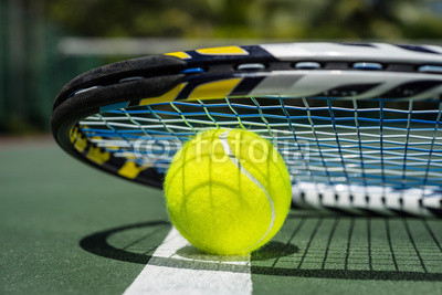 Close up view of tennis racket and balls on tennis court