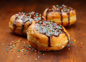 Fototapety Tasty donuts with chocolate on wooden table