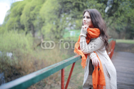young girl in an orange scarf on a walk in the park