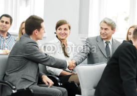 business partners shake hands in the conference room